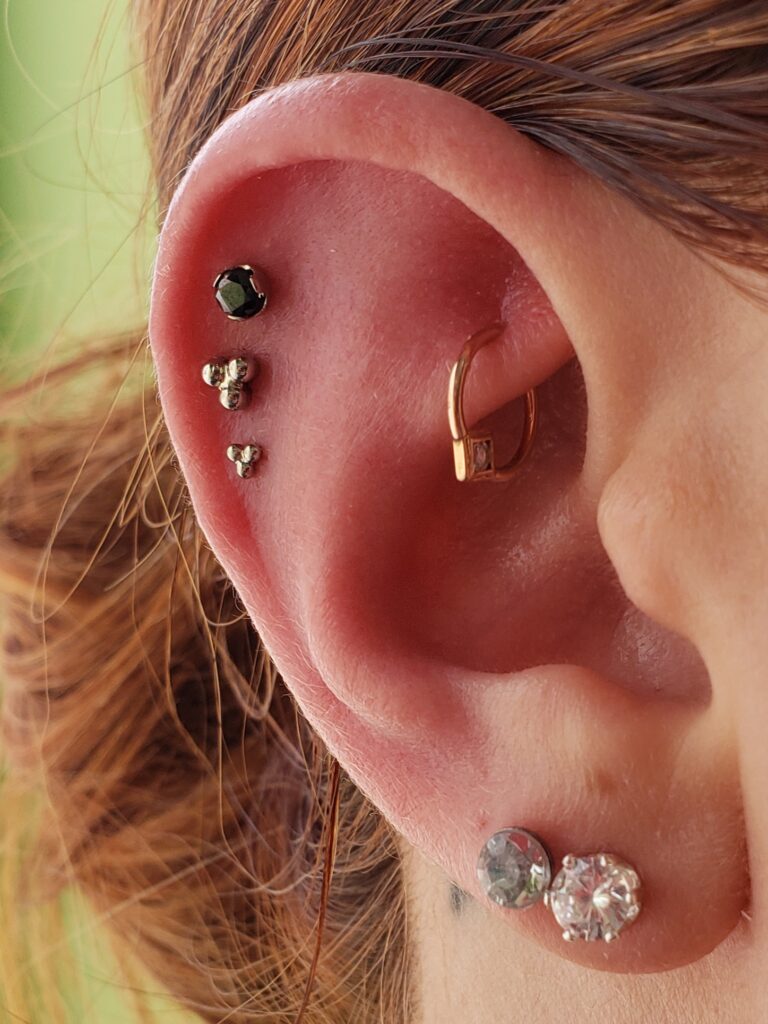 A woman with multiple piercings on her ear.