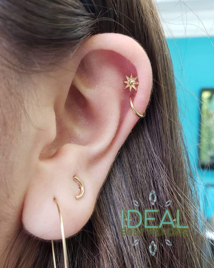 A woman with her ear lobe and ear piercing.