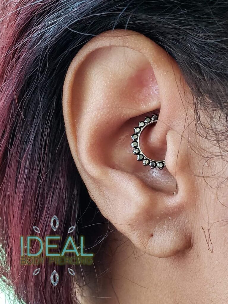 A woman with a black and silver ear piercing.