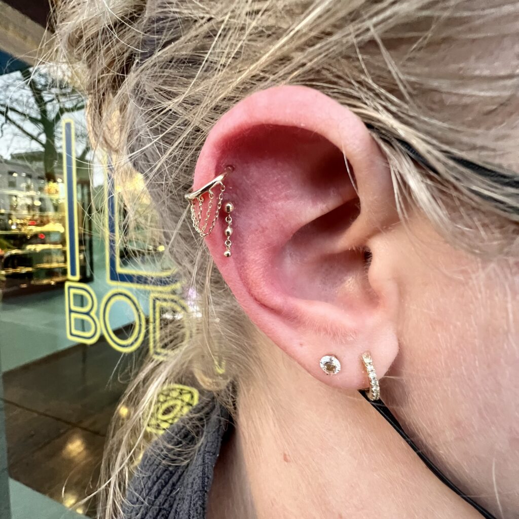 A woman with her ear piercings in front of a store.